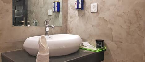 A bathroom with a white sink, a towel, and toiletries on a shelf.