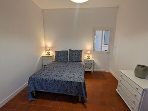 A bedroom with a bed, two bedside tables with lamps, a dresser, and a window. - Charming Riverside Gîte: Family-friendly, Horse-friendly, Perfect for Cyclists (Sigloy)