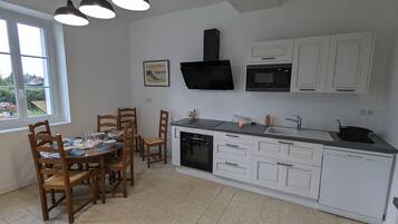 Een koelkast, een microgolfoven, een vaatwasser, een eettafel