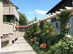 Een smal pad begrensd door gebouwen met houten balkonnes en bloempotten.