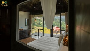 Un dormitorio con una cama grande, una mesita de noche, un espejo y una ventana con cortinas.