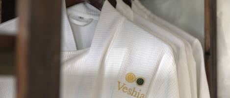 Uma estante com camisas brancas, exibindo um logotipo e texto na parte de trás.
