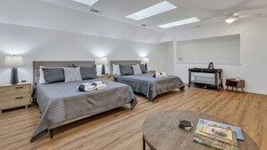 A modern bedroom with two beds, a desk, and a ceiling fan. - Savannah 5BR Pool, Jacuzzi, Firepit, Sports, Games (Savannah)