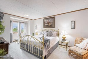 Ein Schlafzimmer mit Bett, Nachttischen, einem Sessel und einem Schreibtisch.