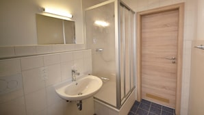 A bathroom with a sink, mirror, and shower. - Holzhammer Hof (Bayerbach)