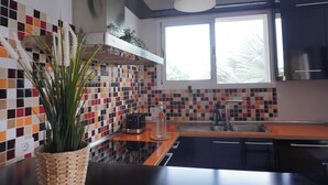 A kitchen with a tiled backsplash, a window with a view, a sink, and a toaster. - Modern House in Bajamar (Bajamar)