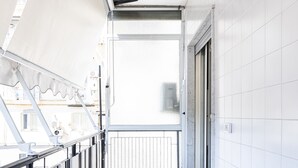 A corridor with white tiled walls and a tiled floor, leading to a door. - Enjoy your holiday in Naples in this brand new apartment (Napoli)