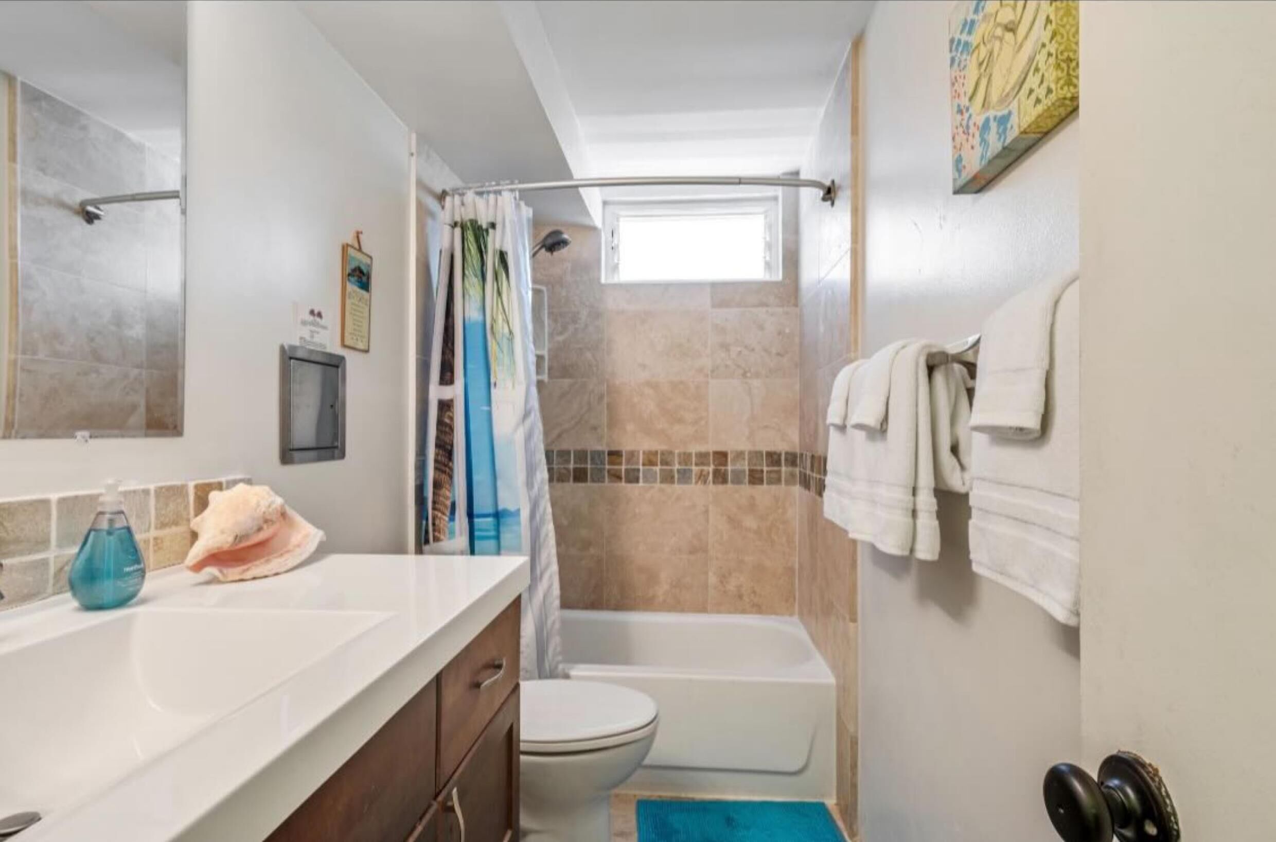 A bathroom with a bathtub, toilet, and shower area.