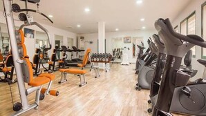 Un gimnasio con diverso equipo de ejercicio, incluyendo cintas de correr y máquinas de pesas.