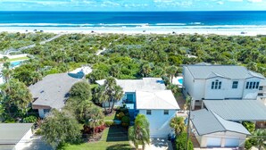 Un quartier résidentiel situé sur la côte, avec des maisons, une plage et une vue dégagée sur l’océan.