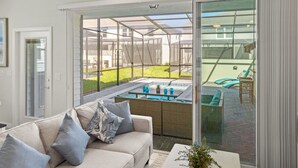 A modern living room with a glass sliding door leading to a backyard patio.