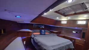 A compact cabin with a bed, a small table, and a bench.