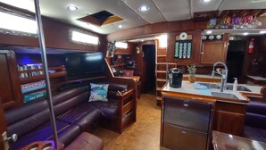 A compact living area with a leather sofa, a small coffee station, and a TV.
