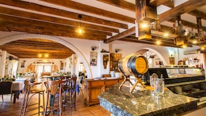 Un interior de restaurante con vigas de madera, una zona de bar y una encimera de piedra.