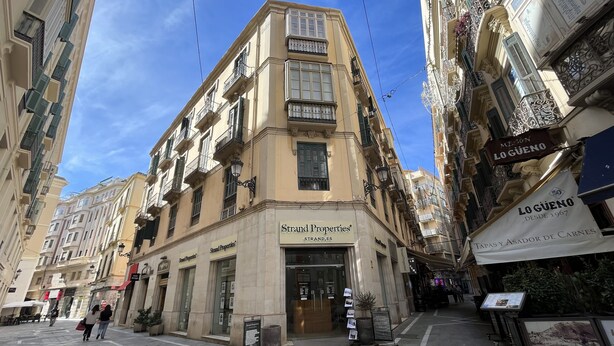 Ein Gebäude mit der Aufschrift 'Strand Properties', das eine Immobilienagentur kennzeichnet.