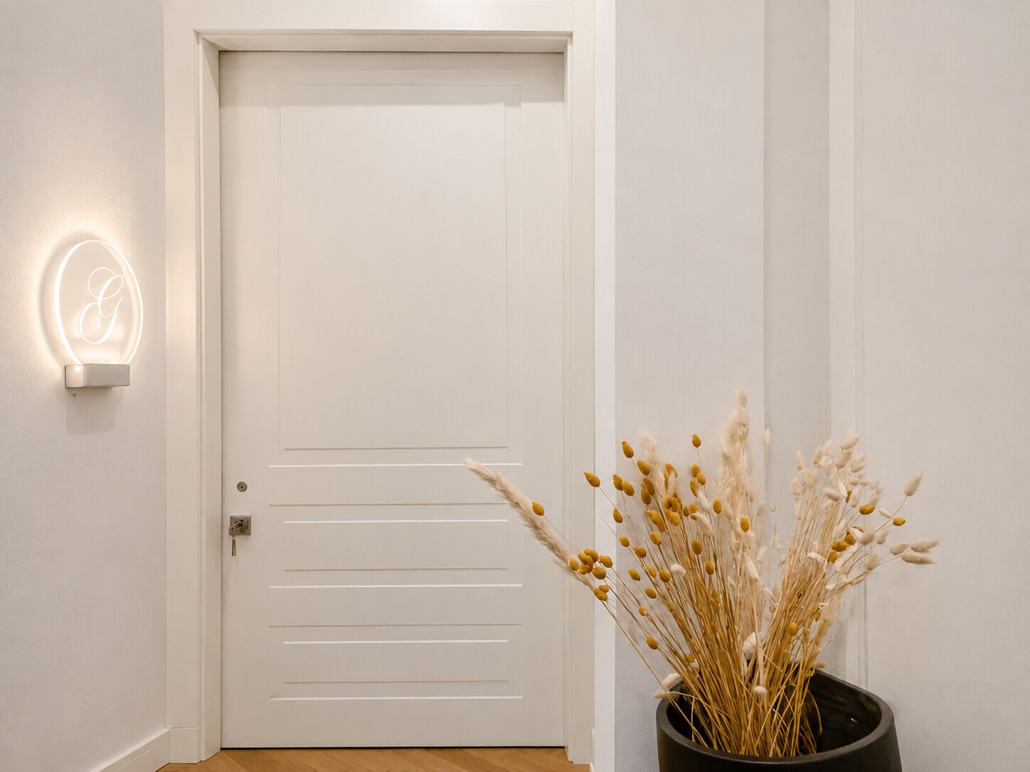 A white door with horizontal lines and a neon sign on the wall.