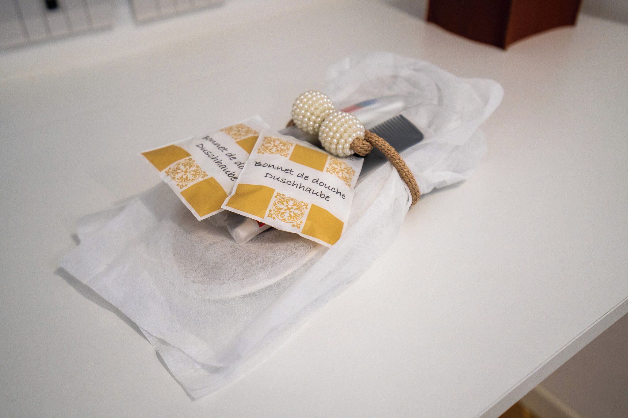 A white table with a tissue box and a comb with a pearl handle.