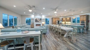 Amplia sala de estar con un sofá grande, mesa de comedor y isla de cocina.