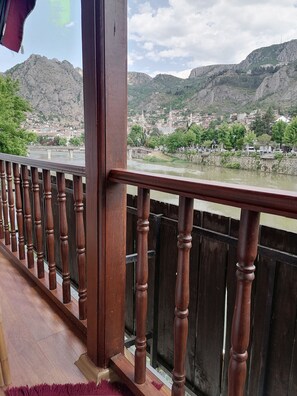 Barandal de madera que da a un río con un pueblo al fondo.
