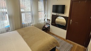 A bedroom with a bed, a TV, a wardrobe, and a window with curtains. - Gönül sefası bütik otel  (Amasya)