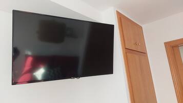Televisor de pantalla plana montado en una pared blanca.
