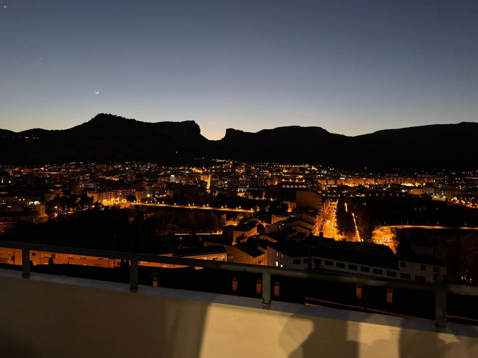 Un paisaje urbano nocturno con un puente y edificios.