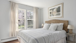 A bedroom with a bed, two bedside tables, a window with curtains, and a framed picture on the wall. - 3bed, 2bath Hamptons Home, Close to Incredible Beaches and Restaurants! (Hampton Bays)