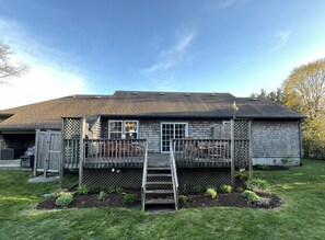 A house with a wooden deck, a covered porch, and a small garden area.