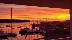 Un port de plaisance au coucher du soleil, avec des bateaux amarrés.