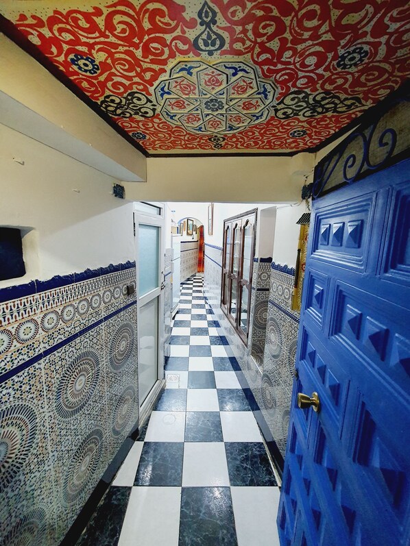 Stunning corridor with intricate tile work and a traditional architectural style, featuring a checkered floor and decorative ceiling.