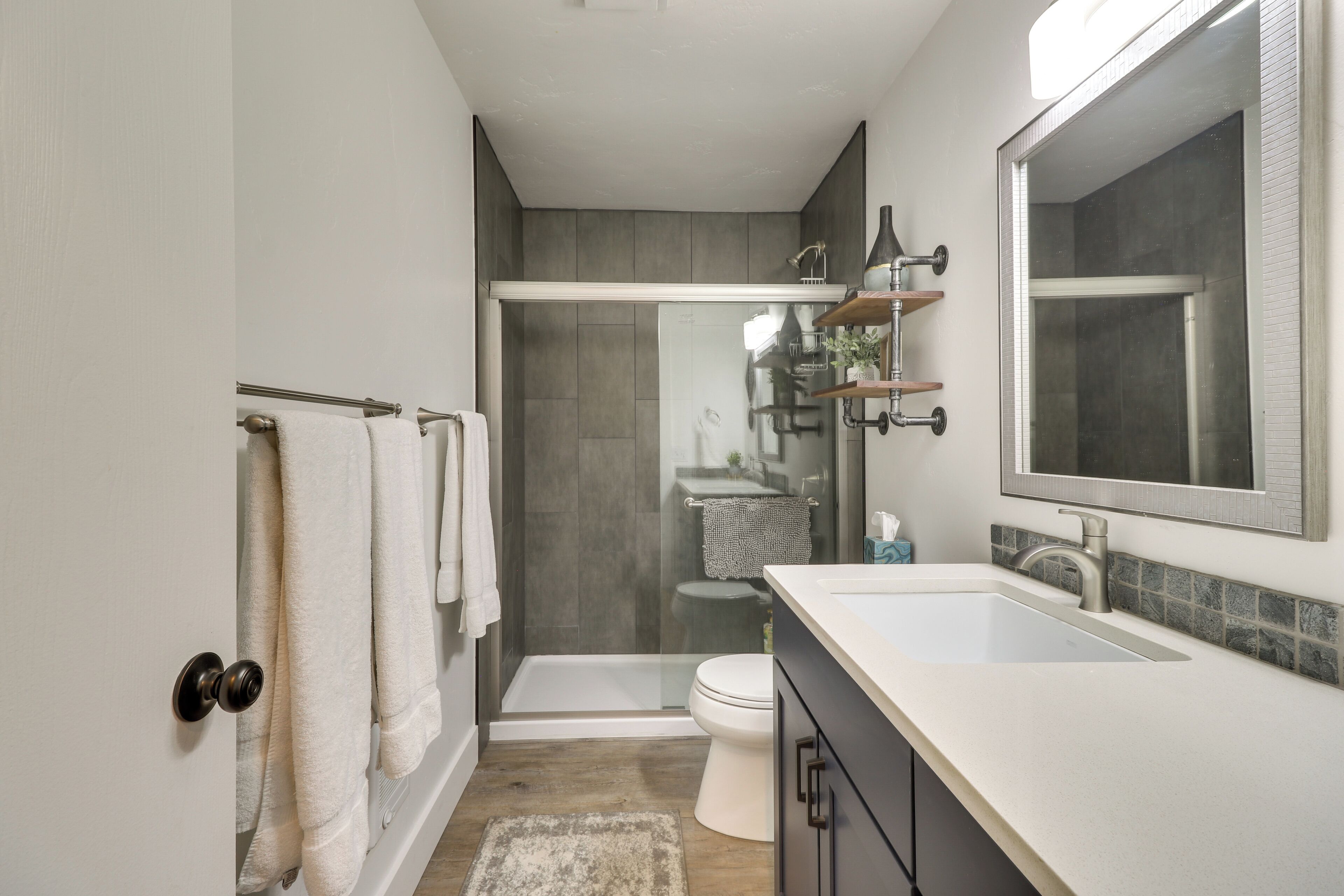 Une salle de bain moderne équipée d’une douche, de toilettes et d’un lavabo.