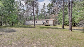 Situated in a wooded area, this single-story home offers a secluded retreat with a flat roof and a small porch.