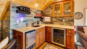 A kitchen with a stone backsplash, wooden cabinets, a built-in oven, and a bar sign. - Hot Tub & Fire Pit: Idyllic Getaway in Angel Fire! (Angel Fire)