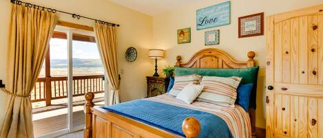 Un dormitorio con una cama de madera, vistas a través de un ventanal corredero, un armario de madera y una pared con un cartel que dice 'Loved you yesterday, love you today'.