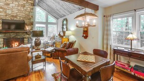 A cozy living room with a fireplace, wooden furniture, and a chandelier.
