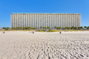 Un grande hotel con una lunga facciata, diversi piani e un tetto piatto.