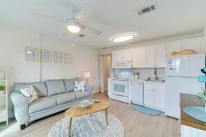 A modern kitchen with white cabinets, a built-in oven, microwave, and a refrigerator. - Swim, Tour & Explore! Gulf Shores Condo w/ Balcony (Gulf Shores)
