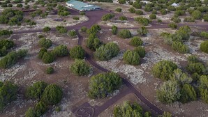 An aerial view of a property with a central building surrounded by a landscaped area with trees and a winding path. - Family Reunions, Groups, 40 acres wide open spaces (Concho)