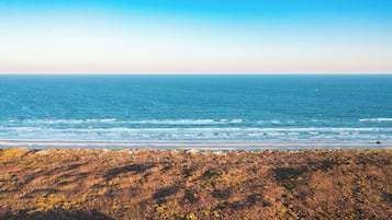A coastal landscape with a view of the ocean and a rocky shoreline.