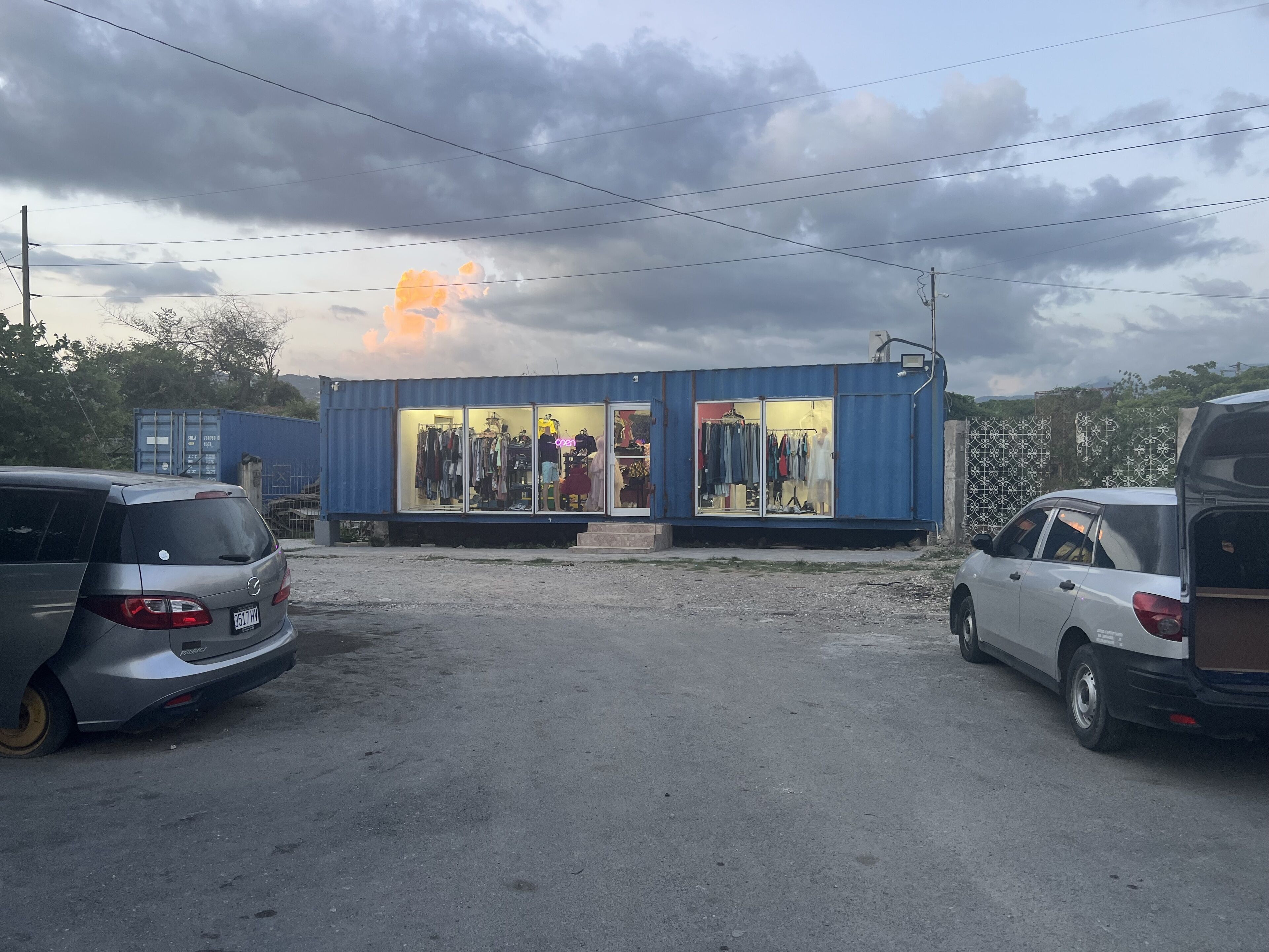 A small, single-story building with a storefront displaying clothing items.