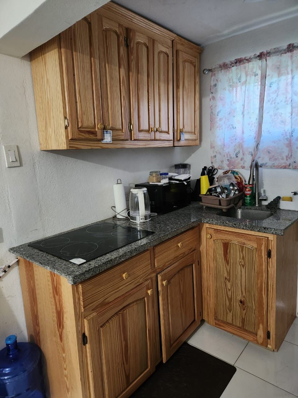 Una cocina con gabinetes de madera, encimera de granito y estufa negra.