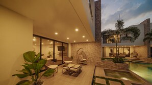 Un patio exterior con mobiliario, una piscina y un diseño de casa moderno.