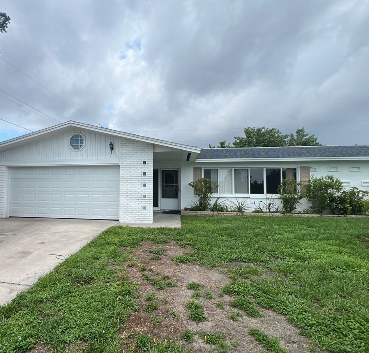 A single-story house with a garage, a front porch, and a small front yard.