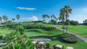 Un parcours de golf avec des allées parfaitement entretenues, des bunkers de sable et un ciel dégagé.