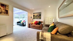 A spacious living room with a large window, a sofa, and a cabinet.