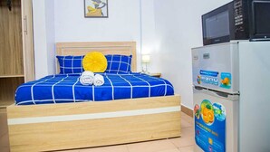A hotel room with a bed, a microwave, and a refrigerator. - Aji  Unique 1BED Studio  (Ijegun, Lagos) (Lagos)