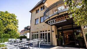 Un immeuble sur lequel on peut lire l’inscription : « CITYHOME, PENSION ».