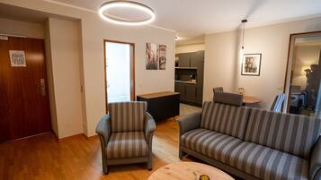 Una sala de estar moderna con un sofá, un sillón y una mesa redonda de centro.