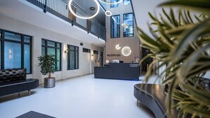 Un espace d’accueil moderne comprenant un comptoir d’accueil, des sièges et un escalier.