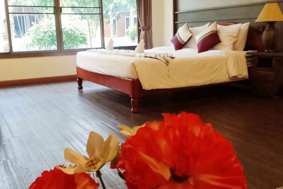 Quarto de hotel com cama, mesa de cabeceira e janela.